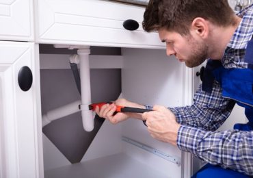 plumbing-services-1-2.jpg plumber repairing the sink plumbing in a residential property