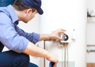 plumbing-services-1.jpg plumber doing maintenance on a water heater